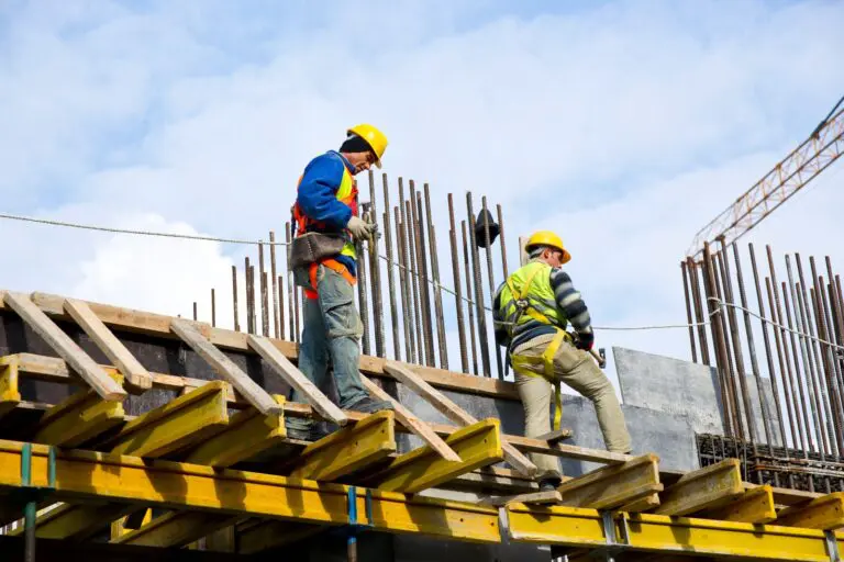 hombres en la construcción con linea de seguridad en un andamio
